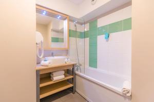 a bathroom with a sink and a shower at Appart’City Confort Montpellier Millénaire in Montpellier