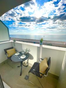 a balcony with a table and chairs and a view of the beach at GATU Villa Camarote con vistas al mar in Cádiz