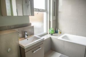 a white bathroom with a sink and a mirror at Lovely 2 bedroom flat in Shepherd's Bush with indoor fire place in London