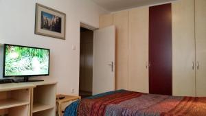 - une chambre avec un lit et une télévision à écran plat dans l'établissement Apartment Iva Tour As with balcony in Ljubljana, à Ljubljana