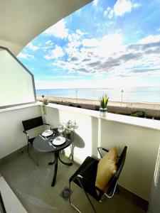 a balcony with a table and chairs and a view of the beach at GATU Villa Camarote con vistas al mar in Cádiz