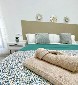 a bedroom with a large bed with a blue blanket on it at GATU Villa Camarote con vistas al mar in Cádiz
