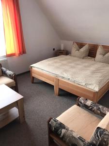 a bedroom with a large bed and a couch at Apartmán Šírovi in Benecko