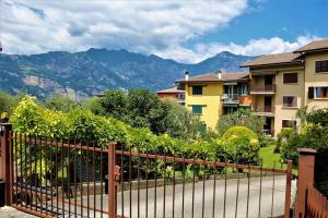 una valla frente a algunas casas y montañas en Andy Apt zona tranquilla vicino centro e spiaggia, en Malcesine