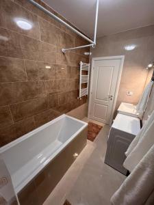 y baño con bañera, aseo y lavamanos. en Apartament 2 camere Proximitate Aeroport, en Iaşi