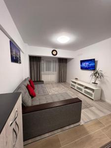 sala de estar con sofá y TV de pantalla plana en Apartament 2 camere Proximitate Aeroport, en Iaşi