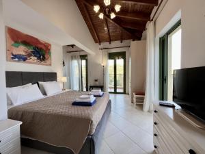 sypialnia z łóżkiem i telewizorem z płaskim ekranem w obiekcie Villa Poseidon w mieście Kateleios