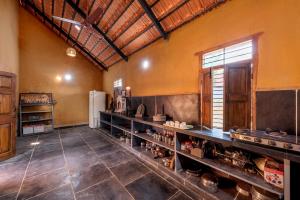 a large room with a kitchen with a refrigerator at CosmicStays Rustic Elegance - Traditional Wada Inspired Living in Shirwal