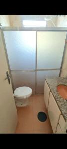 La salle de bains est pourvue de toilettes et d'un lavabo. dans l'établissement Ap lado praia Enseada., à Guarujá