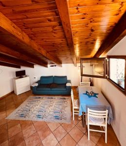 un soggiorno con divano blu e tavolo di JP's House ad Amalfi