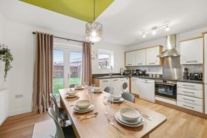 a dining room with a table and chairs in a kitchen at East London Townhouse sleeps 7 with 1 parking space in Goodmayes
