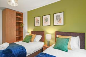 2 camas en una habitación con paredes verdes en East London Townhouse sleeps 7 with 1 parking space, en Goodmayes