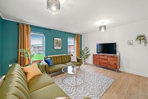 a living room with a couch and a tv at East London Townhouse sleeps 7 with 1 parking space in Goodmayes