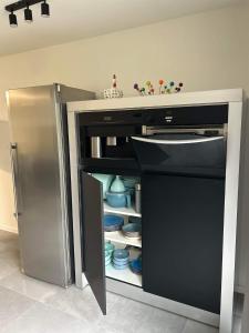 a stainless steel refrigerator with its door open at Chez Gina in Herbeumont