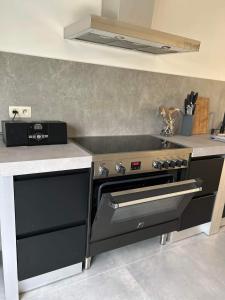 a kitchen with a stove and a counter top at Chez Gina in Herbeumont