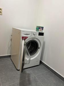 uma máquina de lavar roupa ao lado de uma parede branca em Chez Gina em Herbeumont