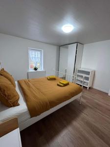 a bedroom with a large bed with two yellow pillows on it at Chez Gina in Herbeumont
