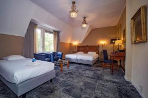 a hotel room with two beds and a desk at Fletcher Hotel Apeldoorn in Apeldoorn