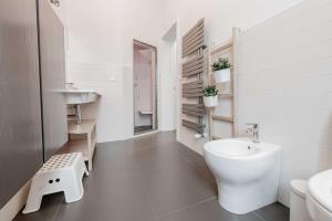 La salle de bains blanche est pourvue de toilettes et d'un lavabo. dans l'établissement Realkasa De Crescenzi Family Apartment, à Bologne