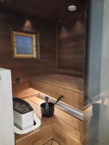 a sauna with a stove and a bath tub at Villa Mustikka, Messilä in Tiirismaa