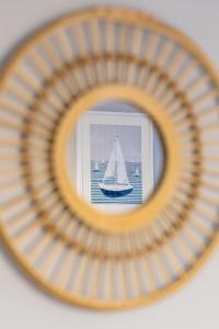 a framed picture of a sail boat in the water at Apartment Leśne Tarasy Dziwnówek by Renters in Dziwnówek