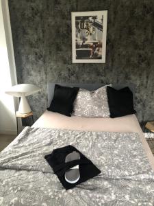 a bed with a black hat on top of it at Body Kult Loft - Modernes Appartement mit 2 separaten Schlafzimmern in Zwickau