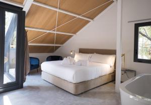 Schlafzimmer mit einem Bett, einer Badewanne und einer Badewanne in der Unterkunft BOX ART ALPINO in Navacerrada