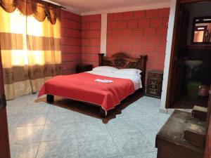a bedroom with a bed with a red brick wall at Casa Hotel Los Faroles- Samaná/Caldas in Samaná