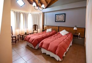 Habitación de hotel con 2 camas y mantas rojas en Glaciares De La Patagonia en El Calafate