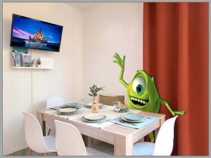 a dining room with a green monster sitting at a table at Salle de jeux enfant 10min de disney transport en commun 1 chambre 4 couchages et 2 dans le salon in Chanteloup-en-Brie