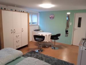 een slaapkamer met een bed, een tafel en 2 stoelen bij Kleine Unterkunft für Selbstversorger in Neurenberg