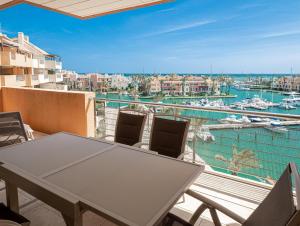 balcón con mesa y sillas y vistas al puerto en Ribera de Marlin 2357 Sotogrande, en San Roque