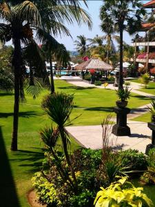 Blick auf einen Park mit Palmen und Pflanzen in der Unterkunft Peninsula Beach Resort in Nusa Dua