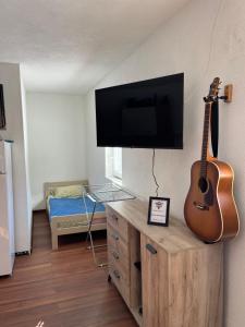 Cette chambre dispose d'un bureau avec une guitare sur un mur. dans l'établissement Casa Illyria, à Gusinje