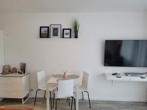 d'une salle à manger avec une table et une télévision murale. dans l'établissement Apartment mit Seeblick Vier Jahreszeiten, à Hahnenklee