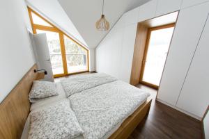 a bedroom with two beds and two windows at Apartman Cornus - Oravská Lesná in Oravská Lesná