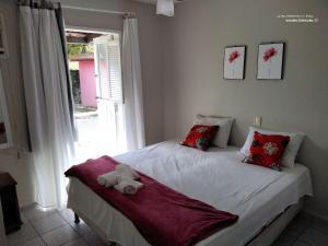 Un dormitorio con una cama con un osito de peluche. en PRAIA DE TAPERAPUAN - FLAT EM CONDOMINIO A 300 METROS DA PRAIA., en Porto Seguro