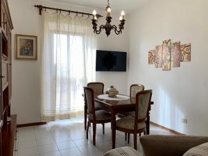 uma sala de jantar com uma mesa e cadeiras e um lustre em CasaTosca em Chianciano Terme