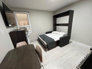 um quarto com uma cama, uma mesa e cadeiras em Le Centre-Ville em Rouyn