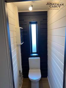 baño con aseo y ventana en Gîtes Douillets : Chalet sur Pilotis, en Houyet