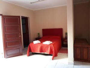 1 dormitorio con cama roja y manta roja en Del Sol 243 en Salta