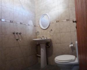 y baño con lavabo, aseo y espejo. en Del Sol 243 en Salta