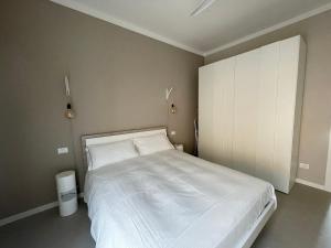 um quarto com uma grande cama branca e um armário em Ca'Sazen Bilo 18 em Brescia