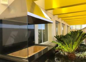a building with a yellow and black facade with plants at FLAT 22º andar totalmente mobiliado lazer completo in Guarulhos