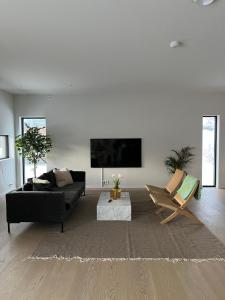 a living room with a black couch and a chair at North Apartment in Tromsø