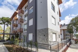 un edificio de apartamentos con fachada en blanco y negro en Rosa Edifício Giardino Cattedral en Canela