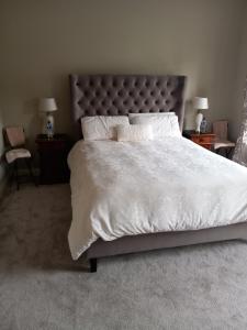 a bedroom with a large bed with white sheets and pillows at Clonoughter Heights in Glin