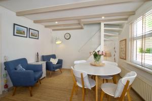 een woonkamer met een witte tafel en stoelen bij Strand & Meer Domburg in Domburg