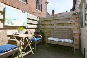 een patio met stoelen, een tafel en een hek bij Strand & Meer Domburg in Domburg