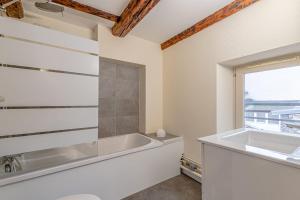 een badkamer met een bad en een raam bij Sous les Toits de Stanislas in Nancy